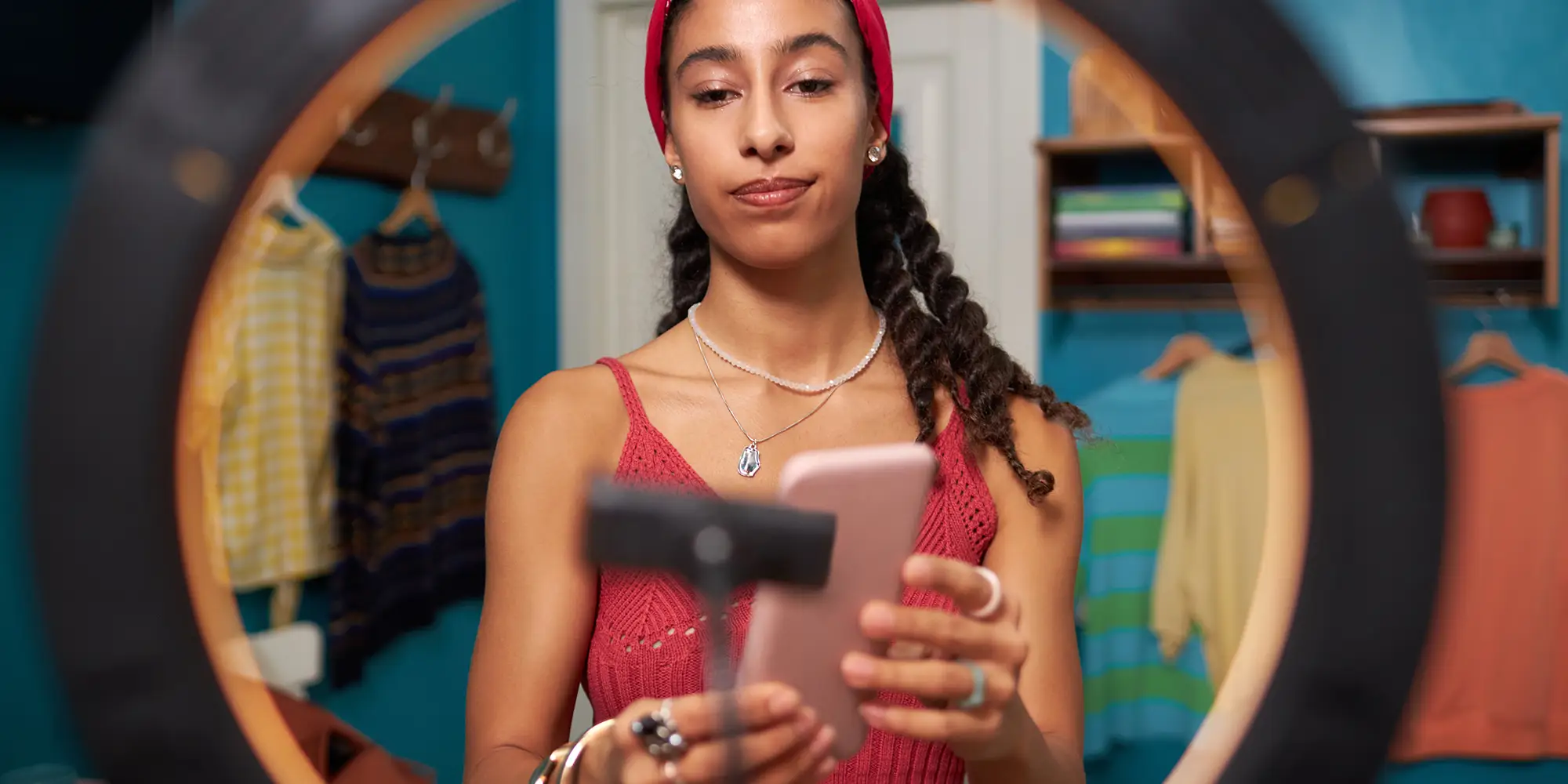 Woman in a closet recording video on mobile phone