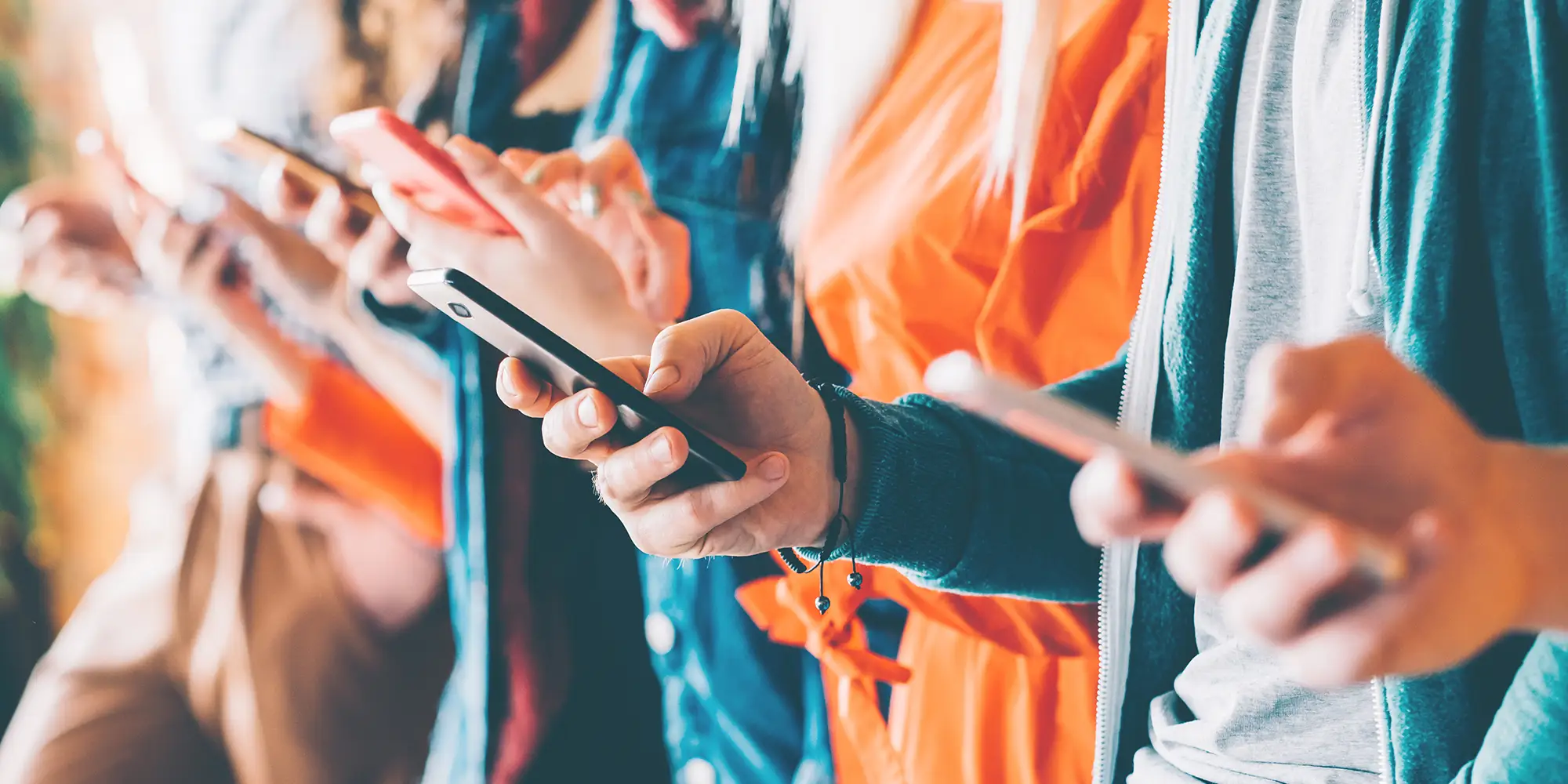 row of people holding mobile phones while scrolling social media