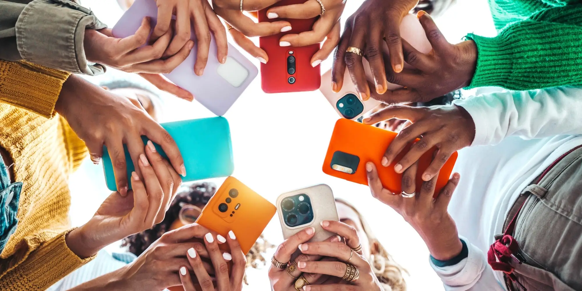group of hands holding mobile phones while browsing Instagram