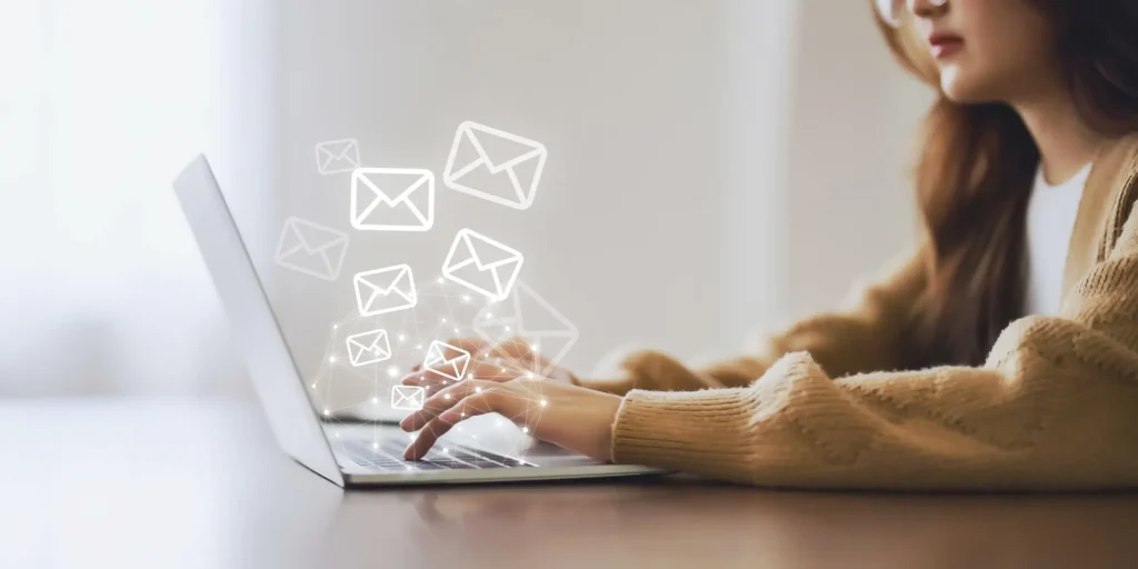 TTG blog image: woman typing on laptop, white email icons coming from screen