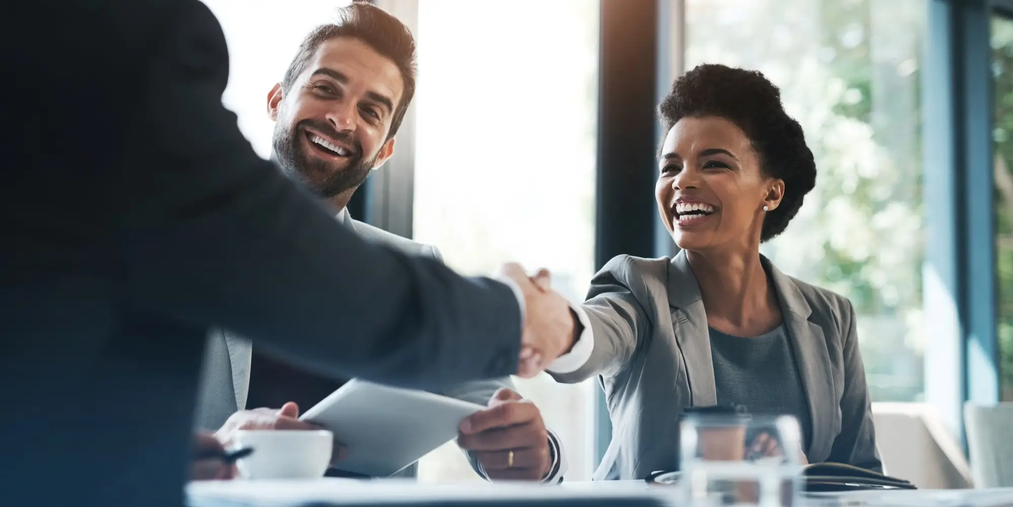 people shaking hands during business meeting