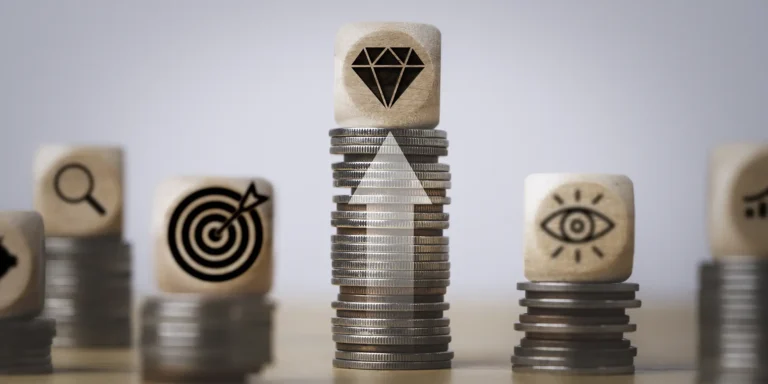 stacks of coins with various wooden blocks symbolizing marketing & sales